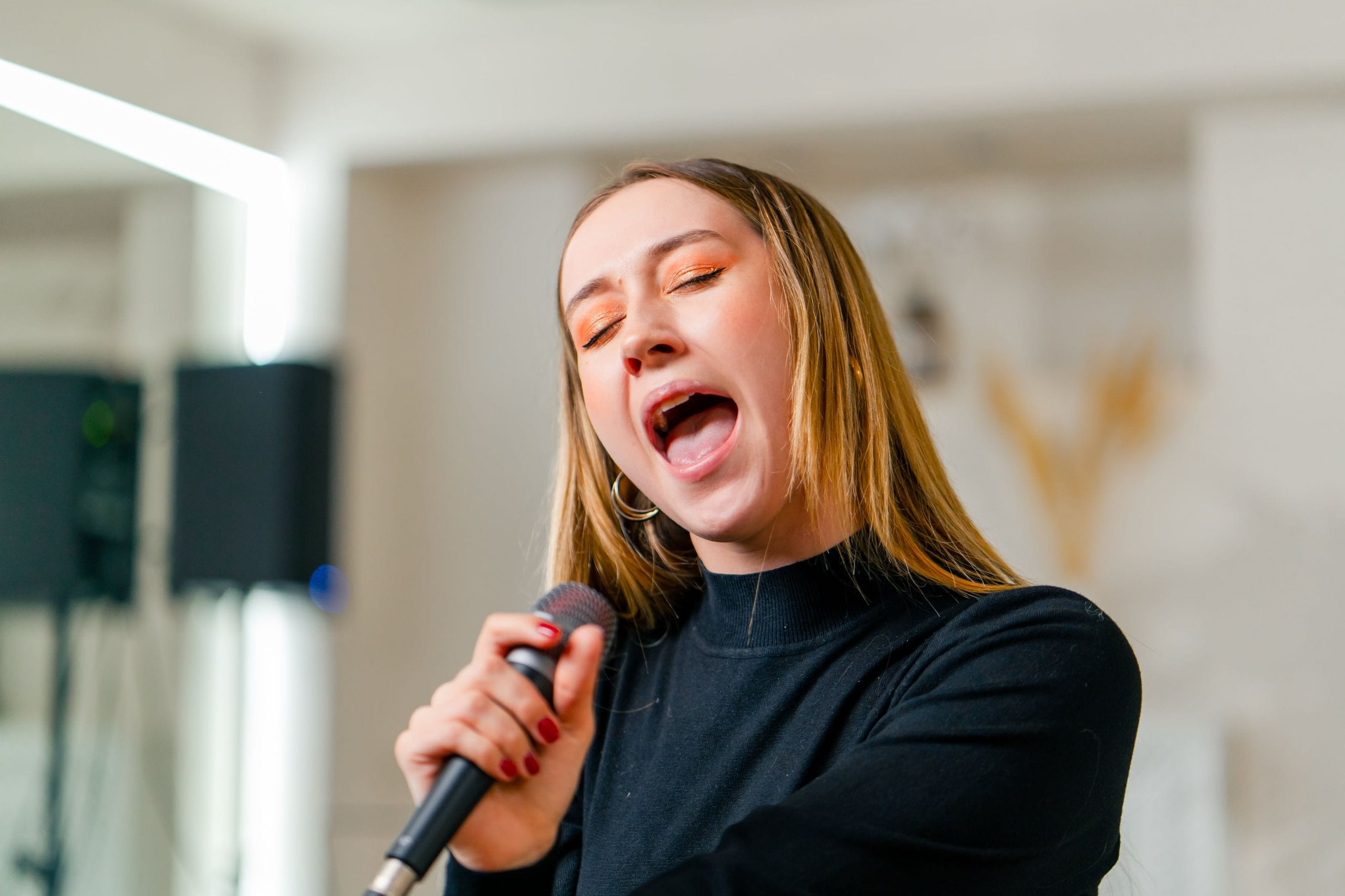 Young girl sings in a vocal lesson with a microphone.